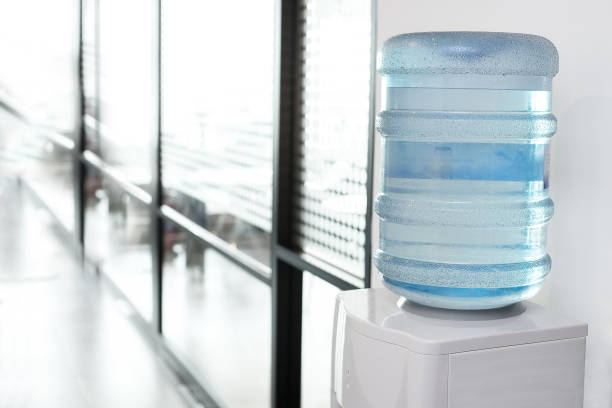 galón de agua azul en el enfriador de agua eléctrica en el área de la oficina - cooler fotografías e imágenes de stock