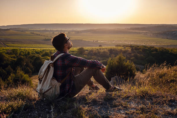 istock Hiker with backpack sitting on top of the mountain 1255585171