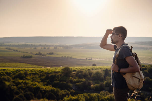 istock A man standing on a mountain as the sun sets. 1255585383