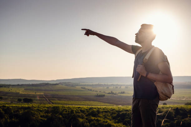 istock A man standing on a mountain as the sun sets. 1255585450