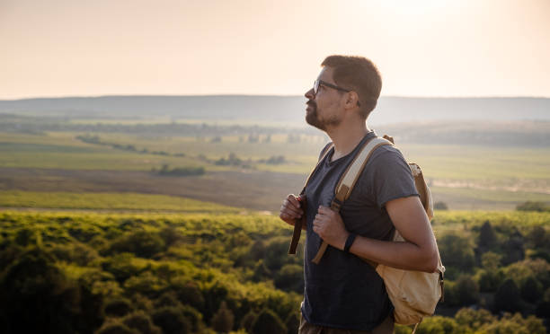 istock A man standing on a mountain as the sun sets. 1255585451