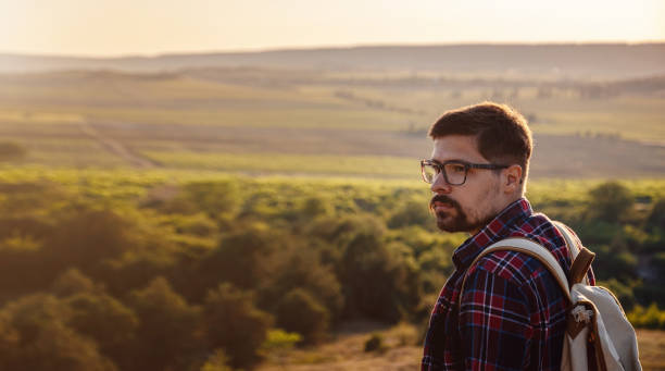 istock A man standing on a mountain as the sun sets. 1255585699