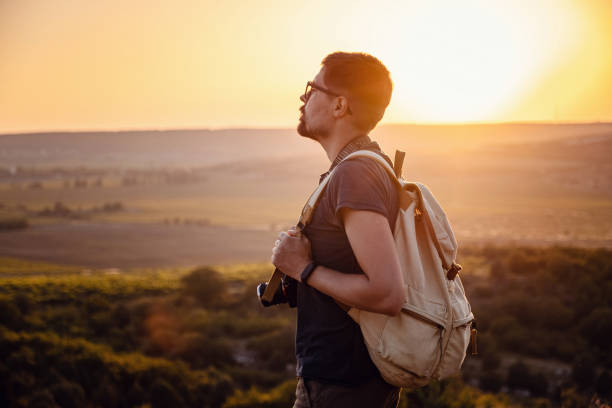 istock A man standing on a mountain as the sun sets. 1255585711