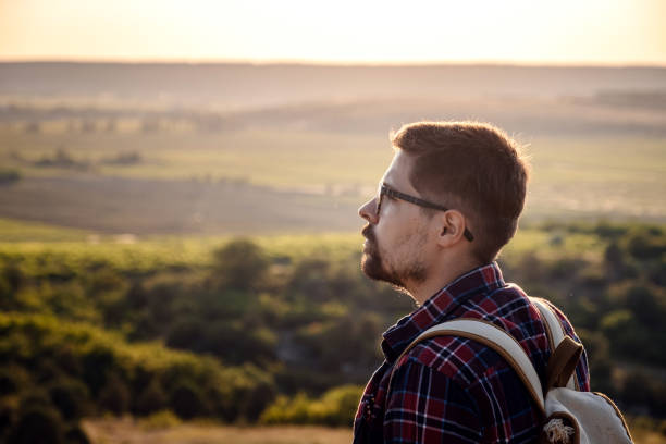 istock A man standing on a mountain as the sun sets. 1255585719