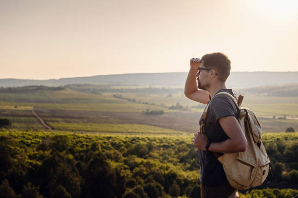 istock A man standing on a mountain as the sun sets. 1255586510