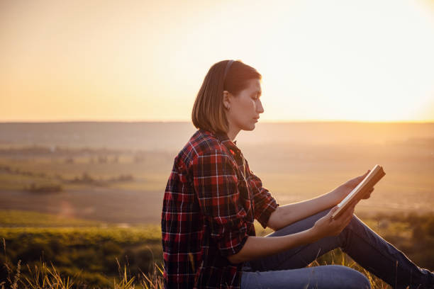 istock beautiful woman writing into her diary, in the park 1255586555