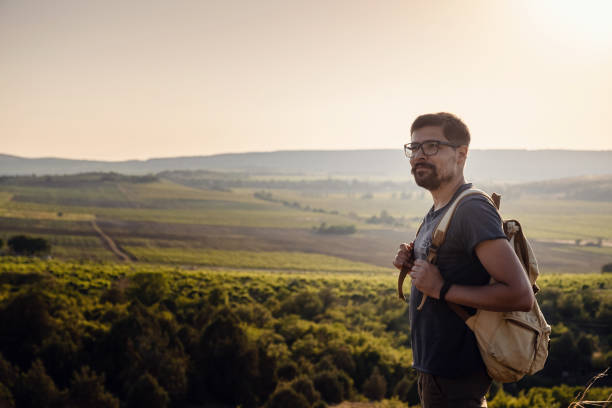 istock A man standing on a mountain as the sun sets. 1255586625