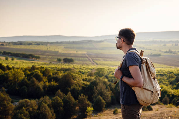 istock A man standing on a mountain as the sun sets. 1255586954