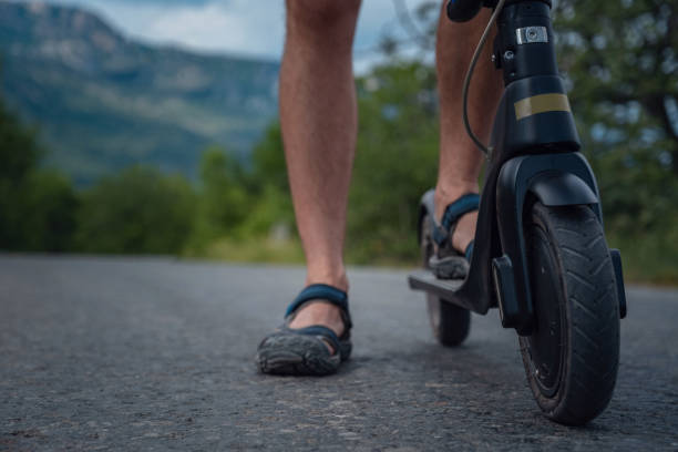 istock Young man riding an electric scooter on mountain range. Ecological transportation concept 1255586963