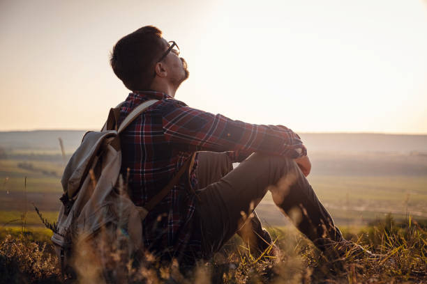 istock Hiker with backpack sitting on top of the mountain 1255587041