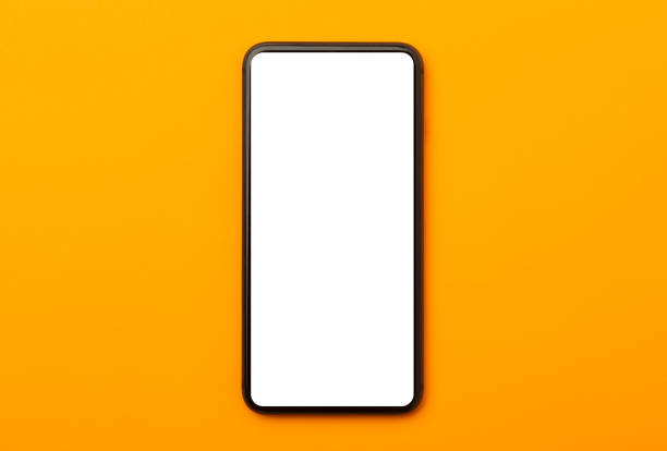 istock Flat lay, top view of orange office table desk with smartphone blank screen mockup with clipping path. Modern working space 1255588332