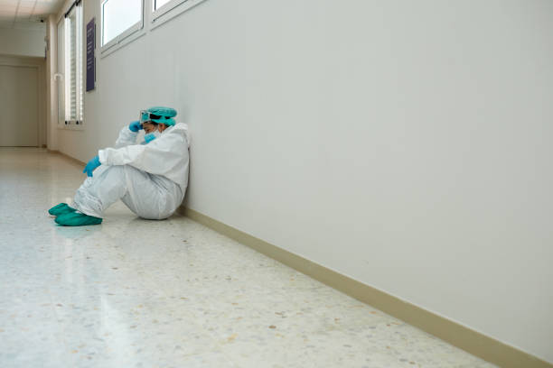 один медицинский работник устал после операции в защитной рабочей одежде covid. - doctor tired protective workwear sadness стоковые фото и изображения
