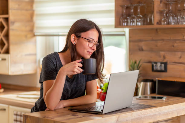 istock Woman drinking coffee and reading news using laptop computer 1255589782