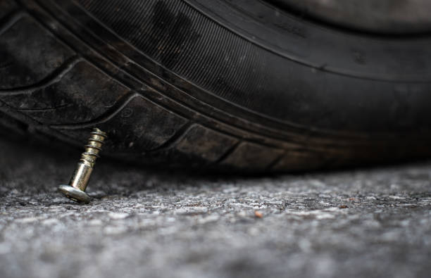 close up button head needle metal screw nail stuck to puncture into wheel tire on the road - truck wheel car macro imagens e fotografias de stock