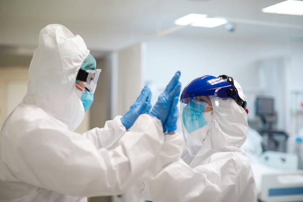 Two healthcare workers giving a high five in support of each other.