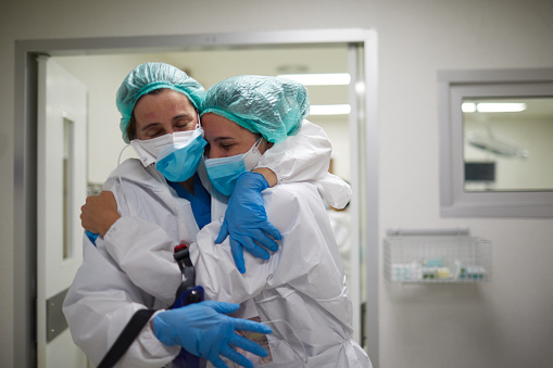 Two doctors hug in celebration of a successful surgery procedure