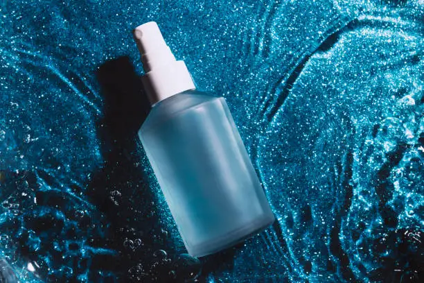 Photo of Transparent cosmetic bottle in water