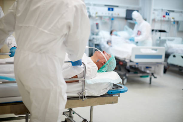 istock COVID hospital workers in PPE coverall pushing a stretcher. 1255591660