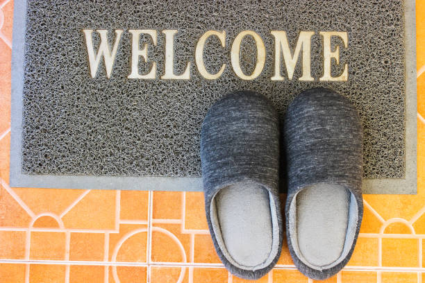istock The grey doormat with the word welcome and slippers 1255591788