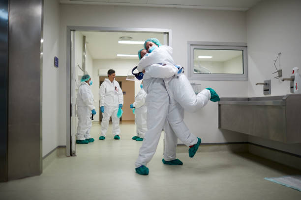 two doctors hug in celebration of a successful surgery procedure - médico geral imagens e fotografias de stock