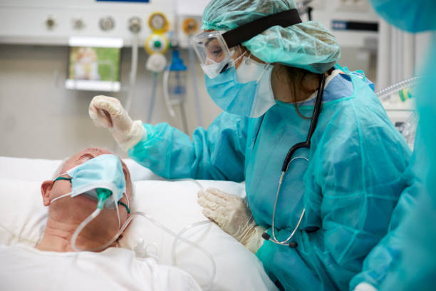 enfermera está consolando a un paciente covid en la uci - reconfortante fotos fotografías e imágenes de stock