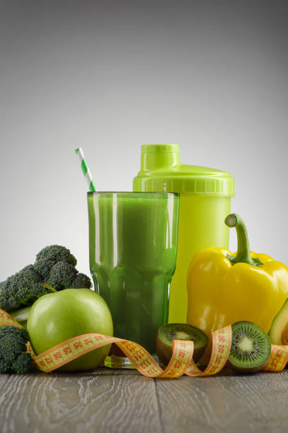 istock Green smoothie and ingredients on gray background 1255592948