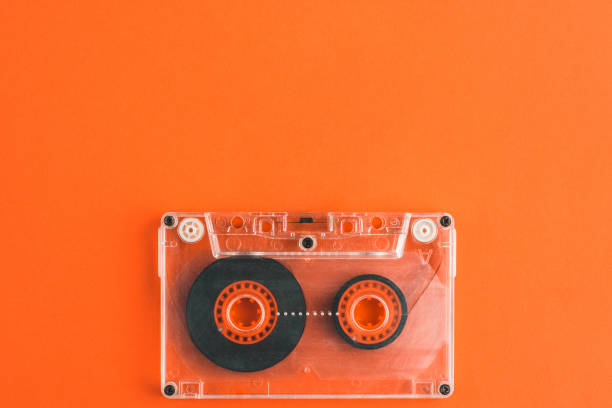 istock Audio tape cassette on orange background, top view. copy space 1255593272