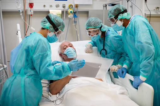 Teacher teaching medical students to perform CPR on a dummy at the hospital - healthcare and medicine concepts