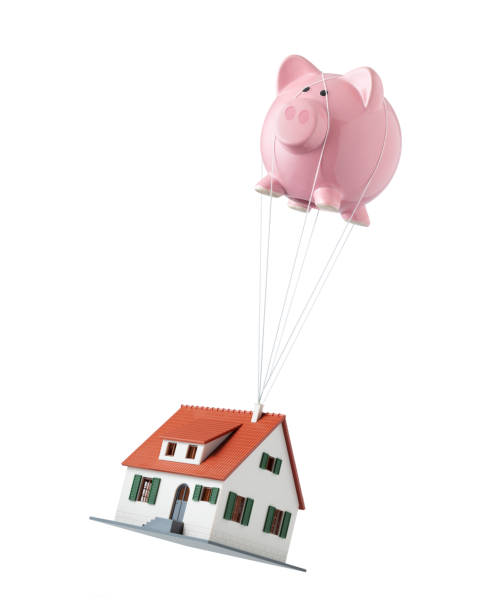 Savings for the house. House lifted by piggy bank hot air balloon. Increase the value of your home. House lifted by piggy bank hot air balloon isolated on white background. Concept photo. real estate signs with balloons stock pictures, royalty-free photos & images