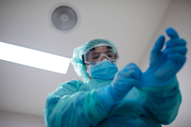 istock One south east asian nurse is putting on protective gloves. 1255593901
