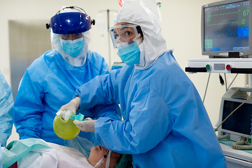 Emergency room, nurses using a medical ventilator on a patient
