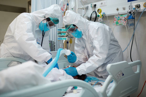 trabajadores sanitarios intubando a un paciente covid. - ventilador equipo respiratorio fotografías e imágenes de stock