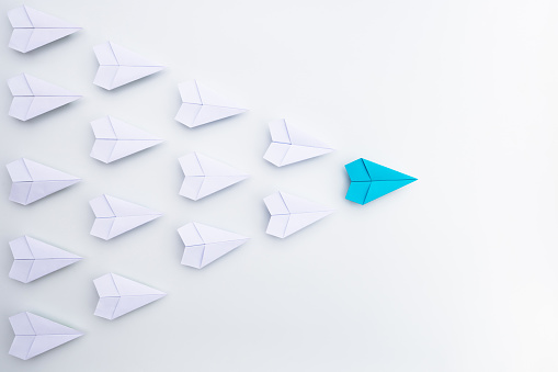 Leadership concept with blue paper plane leading, white background