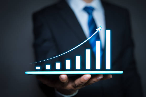istock Businessman holding a tablet computer and growing chart floating above digital tablet computer screen. graph corporate growth plan concept 1255594312