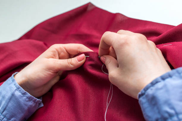 istock Seamstress sews clothes by hand. Woman's hands close up. 1255596240