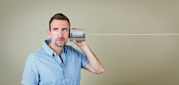 Man listening to tin can telephone