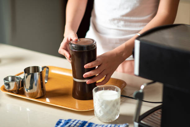 istock Woman using coffee grinder to get powder while making coffee at home 1255598938