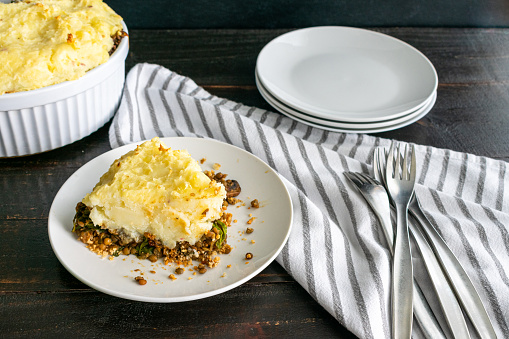A slice of a meat-free cottage pie made with potatoes, lentils, and mushrooms