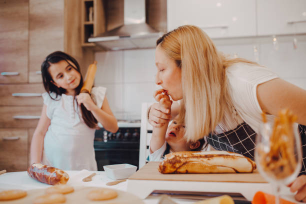 istock Cute small child daughter helping mum kneading preparing dough 1255601422