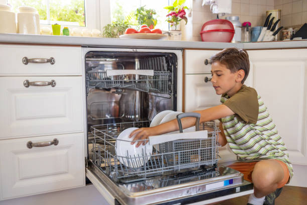 istock Little boy loading the dishwasher at home 1255601574