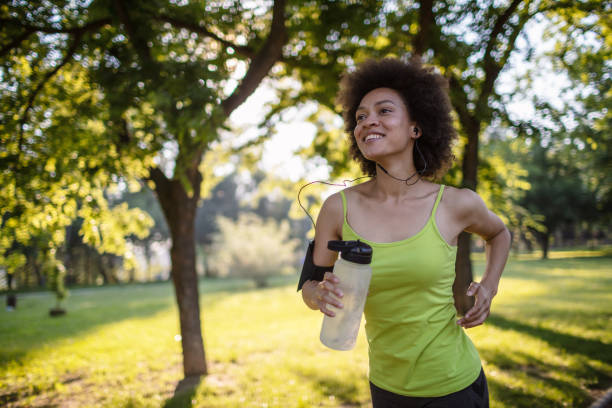 istock Young woman running in a public park 1255602312