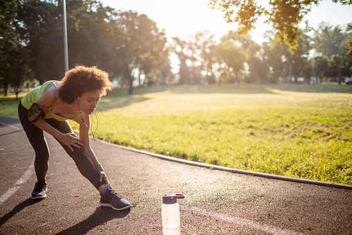 Mixed race woman exercising in the park ,she doing stretching exercises