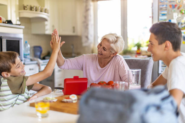 istock Mother preparing healthy lunch boxes for her two sons before going to school 1255604536