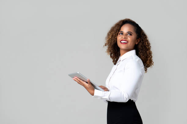 istock Smiling confident African American businesswoman looking up while holding tablet 1255604826