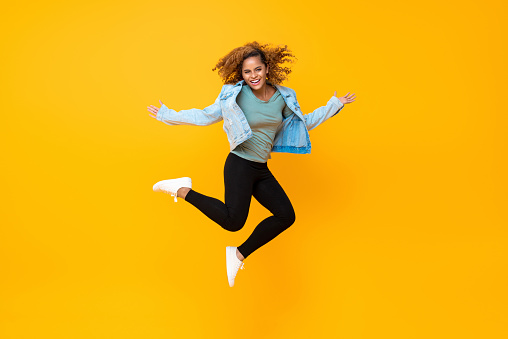 Feliz enérgica sonriente joven mujer afroamericana saltando photo