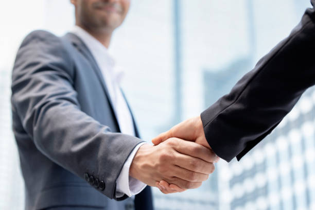 istock Businessman making handshake with partner outdoors for merger and acquisition concept 1255604862