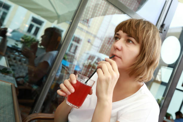 istock Woman has fruit drink on terrace 1255605934