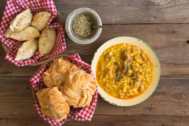 plate with empanadas, portion of locro, fried cakes and mate, traditional Argentine menu