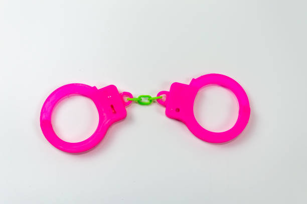 istock The toy handcuffs are pink on a white background. 1255607396