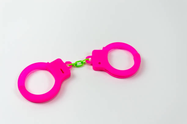 istock The toy handcuffs are pink on a white background. 1255607703